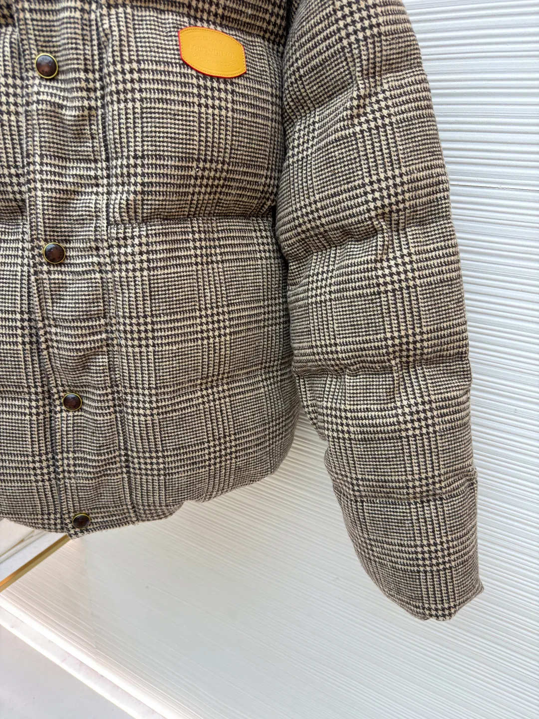 LOUIS VUITTON Tweed Plaid Tunic Stand Collar Long Sleeve Cotton Jacket ●Original version: Purchased and developed by 28699 ●Item No.: 1682302-C95 ●Fabric: Alpaca fabric ●Technology: Made by positioning cutting machine ●Color: Camel ●Version: Fitted version ●Weight: about 1725 grams ●Size: S-M-L-XL ●Description: This plaid down jacket is made of high-count wool-blend plaid fabric. It has been woven and dyed to create a rich brown-toned plaid texture. The fabric has been pre-shrunk and anti-pilling finished to give both texture and durability. The filling is made of gold-matched velvet material of 90% white goose down and 10% white goose feather, which is evenly distributed through the three-dimensional lattice filling process to eliminate the problem of velvet running; the stand-up collar version adopts a double-layer composite lining to lock the temperature, and the placket is customized with matte metal snaps and resin buttons of the same color, which fits the overall retro texture. The left chest is inlaid with a hand-polished cowhide logo plate, and the edges are oil-sealed. Each stitch adopts a 3cm/12-needle precision sewing standard, combined with the seamless taping process of invisible pockets, integrating functionality and craftsmanship details, fully displaying ingenuity and craftsmanship. The overall wiring is straight and delicate, the fabric is comfortable and soft, and the color is consistent without color difference. It can be matched with the same style to create a fashionable look and control various occasions. Customized accessories, complete with three standards, same style for men and women!